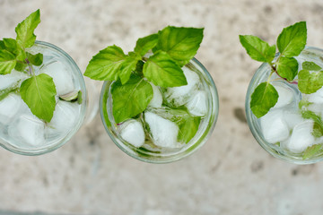 Summer hot fresh drink with mint in glass on white green grey background