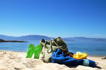 bag, towel, sunglasses and flip flops, summer accessories on the beach