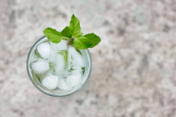 Summer hot fresh drink with mint in glass on white green grey background
