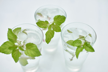 Summer hot fresh drink with mint in glass on white green grey background