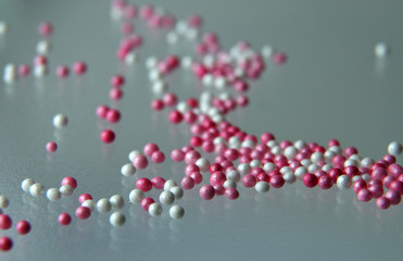 pink and white sugar pearls on a glass table