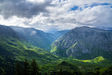 Fototapeta na wymiar Montenegro, Spectacular tara river canyon nature landscape of green forested giant mountainside crossed by tara river in magical light after rain in durmitor national park near zabljak