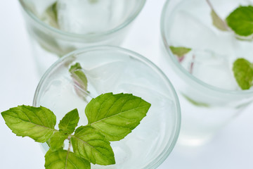 Summer hot fresh drink with mint in glass on white green grey background