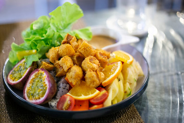 Vegetables and fruits salad with fried chicken meat, lettuce, orange, pineapple, dipping sauce. Healthy food lifestyle recipe.