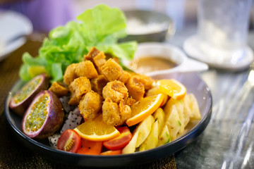 Vegetables and fruits salad with fried chicken meat, lettuce, orange, pineapple, dipping sauce. Healthy food lifestyle recipe.