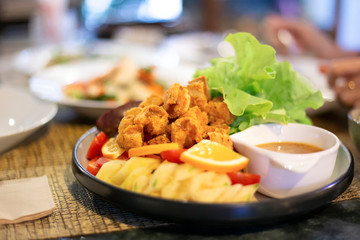 Vegetables and fruits salad with fried chicken meat, lettuce, orange, pineapple, dipping sauce. Healthy food lifestyle recipe.