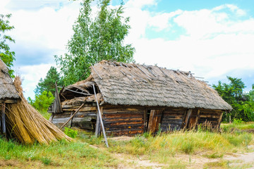 Fototapeta na wymiar Folk abandoned oldest habitation under a reed roof in the disappearing village of Svalovichi in the Ukraine. Ukrainian Polissya.