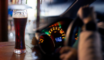 Hands on steering wheel a car moves at fast speed at the night with beer glass. Accident from drunk driving dangerous on the road concept.