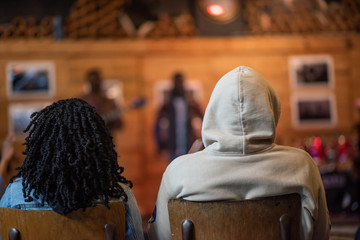 Audience sitting and watching artist perform