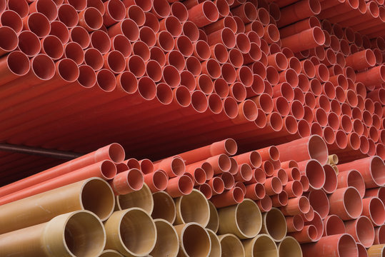 Industrial orange ppr tubes are neatly stacked, orange round tubular background material