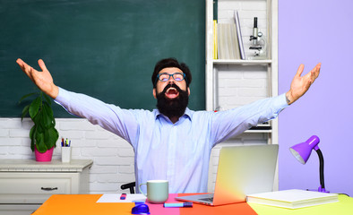 Back to school and happy time. Friendly teacher in classroom near blackboard. Education, learning...