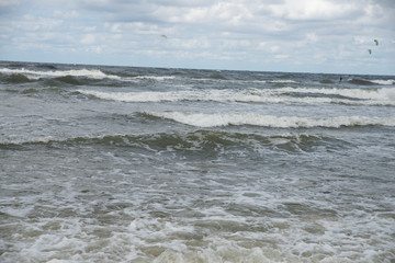 waves at sea and kitesurfing in the background