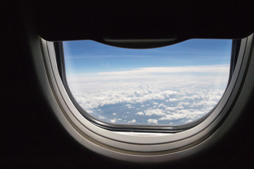 Fototapeta premium Window seat an open half-space in airplane with blue sky and clouds. Nice view seen from plane.