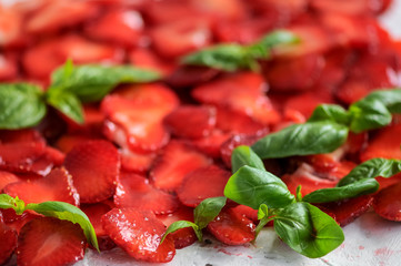 plate of strawberries with sliced ​​basil leaves