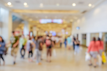 Abstract blurred background of people walking around modern interior building in the city.