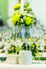 Luxury party dinner table setting with tableware and silverware and glasses set and Candlestick and flower in restaurant.