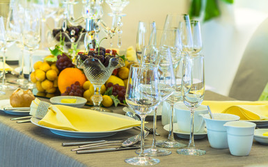 Luxury party dinner table setting with tableware and silverware and glasses set and Candlestick and flower in restaurant.