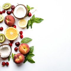 Tropical concept made of peach, kiwi, lemon, cherries, oranges and coconut. Creative summer idea, food background