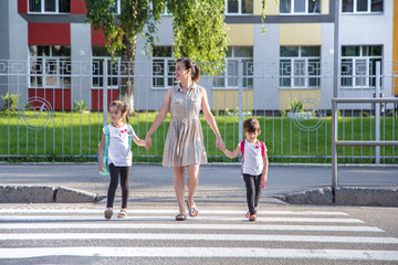 Back to school education concept with girl kids, elementary students, carrying backpacks going to class