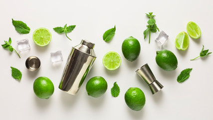 Mojito lime set, flat lay on white background. Concept: Mojito Cocktail. Whole juicy limes with ice...