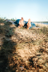 Male and female legs. A man and a woman lie on the ground and rest together.