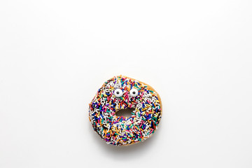 Funny shock face chocolate donut with sprinkles on a white background, creative minimal food concept with copy space