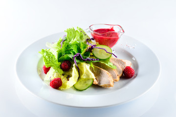 salad with chicken fillet and fresh berries on a light background