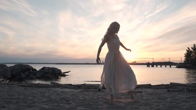 beautiful girl dancing at sunset on the shore