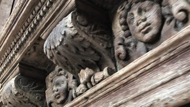 Angels Faces carved in wood on a facade of a medieval church in France