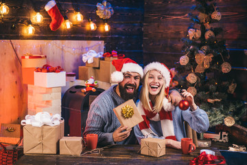 Beautiful Couple dressed in a Santa Claus hat. New Year concept. Family christmas happy. Merry Christmas and Happy New Year. Happy new year. Hoppy couple over christmas tree lights background.