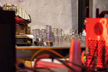 Empty glasses, stacked upside down behind small bar counter desk