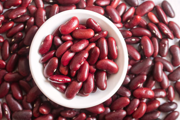 Red beans in white bowl on wooden background.