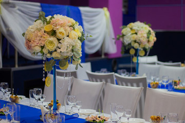 Wedding table decorated with flowers, beads, lemon. With blue track on the table. Yellow flowers. 