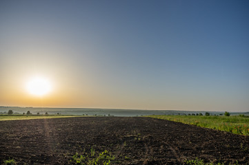 Plowed field at sunrise in summer