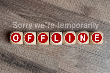 Cubes and dice on wooden background with message Sorry were temporarily offline