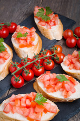 Traditional Italian bruschettas with cherry tomatoes on stone plate
