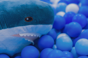 Colorful balls and shark stuffed animals.