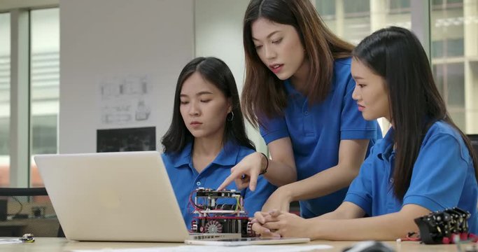 Young asian creative engineers meeting, programming for collaborative universal robotics at laptop in workshop. People with technology or innovation concept.