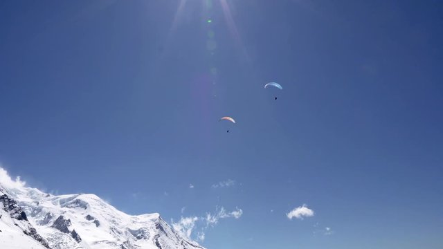 Paraglider flying over snowy mountains. paragliding against the backdrop of the monblan mountain