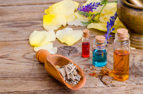 Glass bottles of aroma essential oil on wooden background, image for alternative therapy medicine