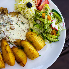 Roast pork with mushrooms and potatoes, tomato, cucumber and cabbage salad