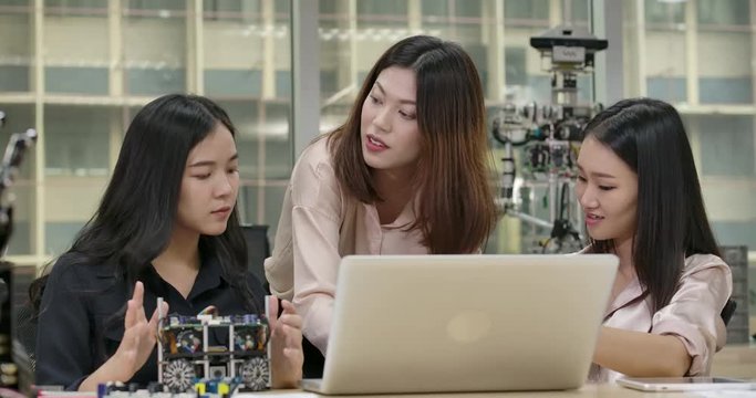 Young asian creative engineers meeting, programming for collaborative universal robotics at laptop in workshop. People with technology or innovation concept.