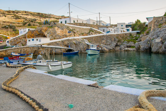 Potamos village with the port and the colorful fishing boats sailing in the turquoise sea waters in Antikythera island in Greece