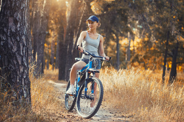cute woman cyclist cycling mountain bike on Pine forest trail