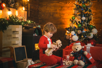 Childhood memories. Santa boy little child celebrate christmas. Boy child play near christmas tree. New year countdown. Merry and bright christmas. Baby enjoy christmas. Favorite toy. Family holiday