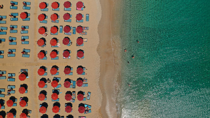 Aerial drone photo of famous organised with sun beds and umbrellas beach of Lia with emerald clear sandy sea shore, Mykonos island, Cyclades, Greece  