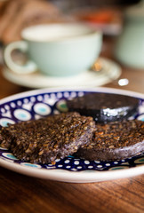 traditional scottish Haggis are served for breakfast on a hand painted plate with a blurred...