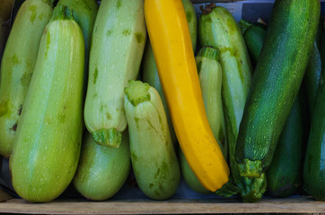Fresh young zucchini in a box on the market.