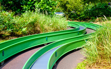 colorful long slide view in public forest playground