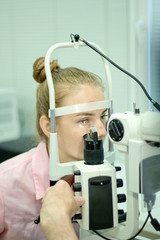 A young woman undergoes an ophthalmological examination, checking the health of the eyes and visual acuity.